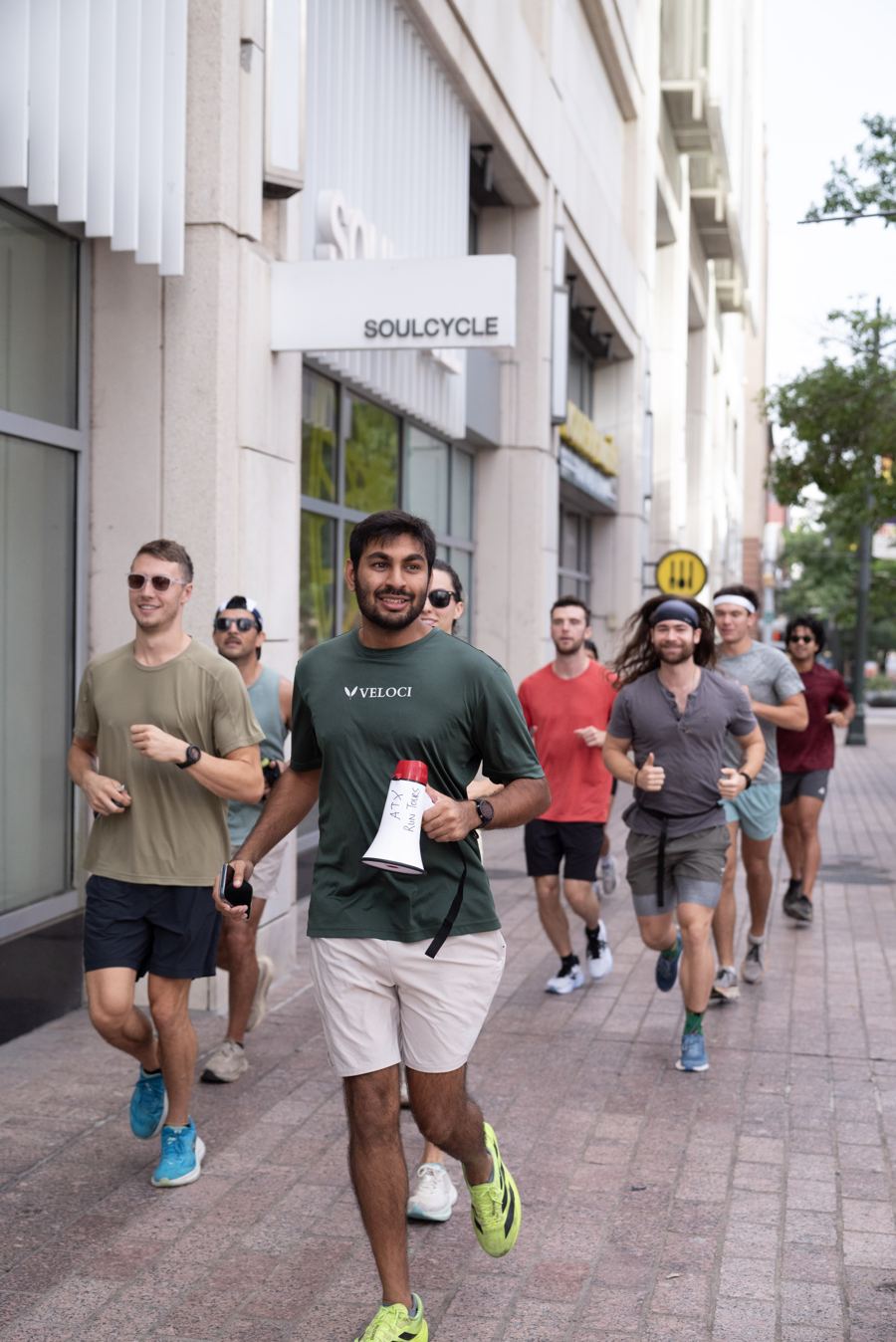 The guide running at the front of the group on a downtown sidewalk